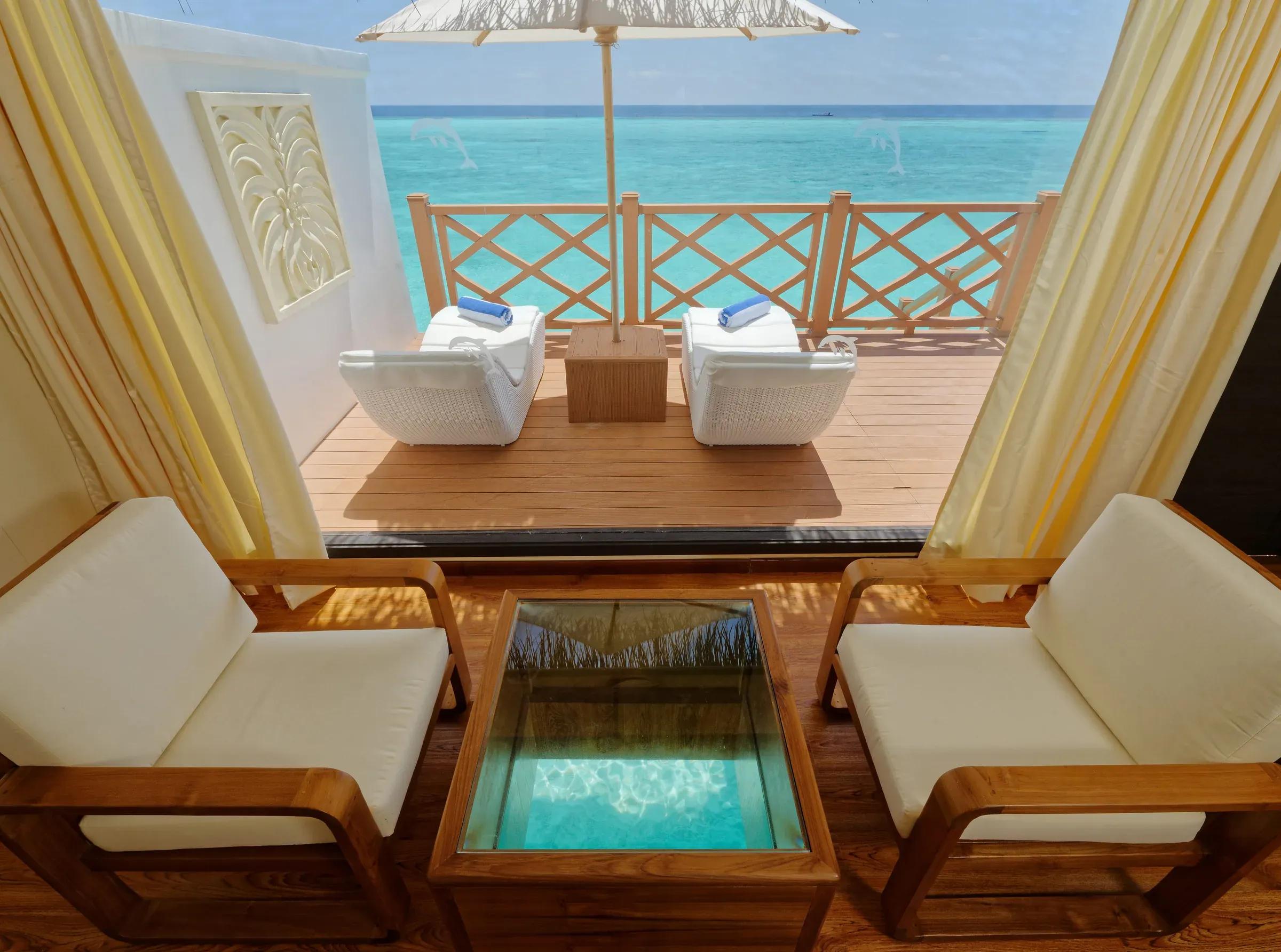 Terrazza del Premium Water Bungalow con sedie bianche e vista mare al Angaga Island Resort & Spa.