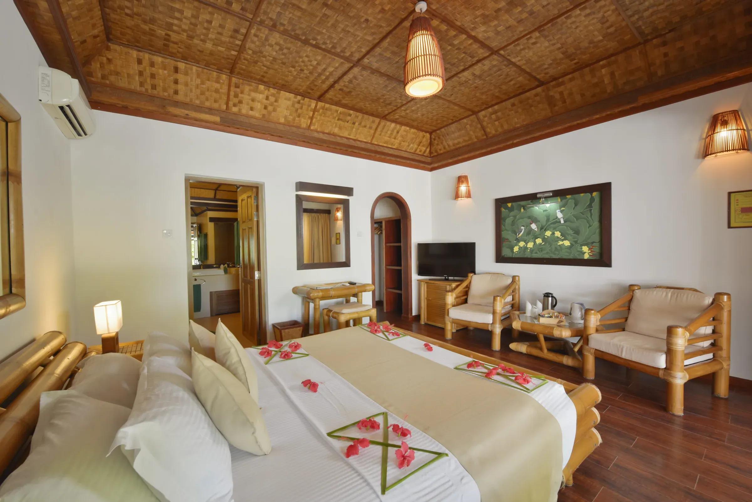 Interno del SUPERIOR BEACH BUNGALOW con letto matrimoniale e area soggiorno al Angaga Island Resort & Spa.