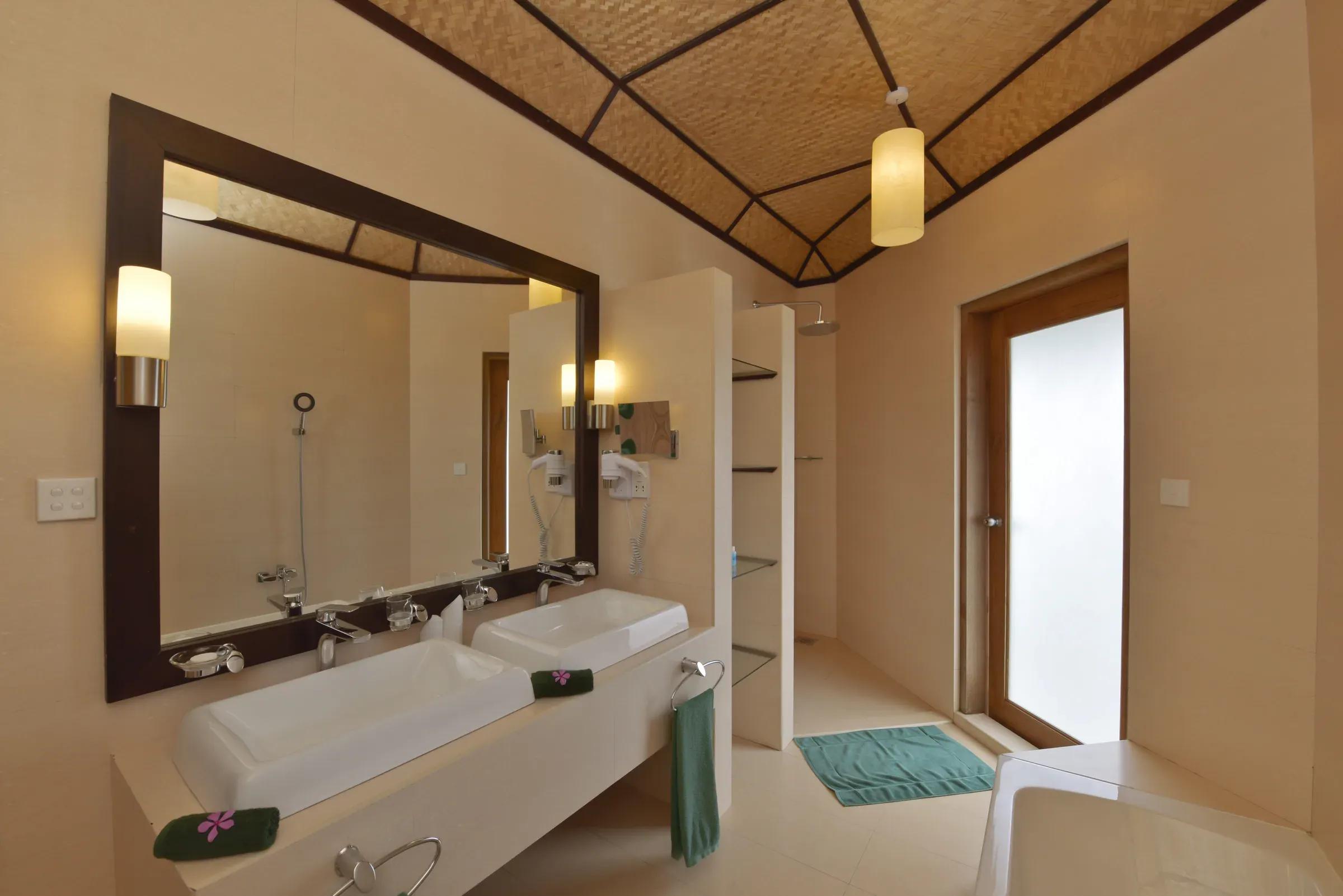 Bagno della SUPERIOR WATER BUNGALOW con doppio lavabo e doccia al Angaga Island Resort & Spa.