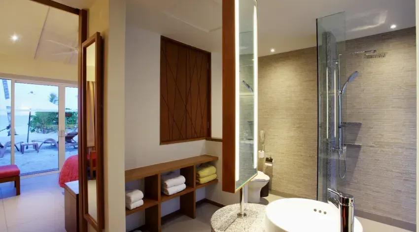 Interno della Lagoon View Beach Villa con bagno moderno e accesso alla terrazza del Centara Ras Fushi Resort & Spa Maldives.