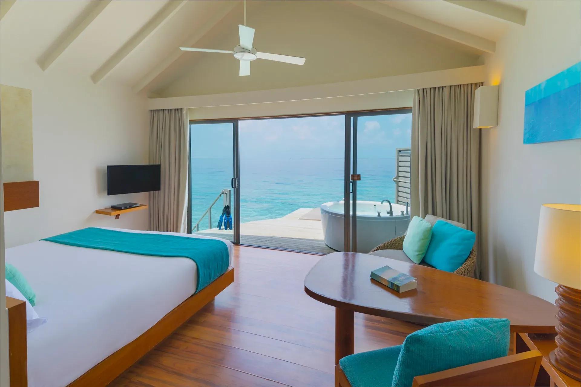 Camera Overwater Villa con vista sull'oceano e vasca esterna al Centara Ras Fushi Resort & Spa Maldives.