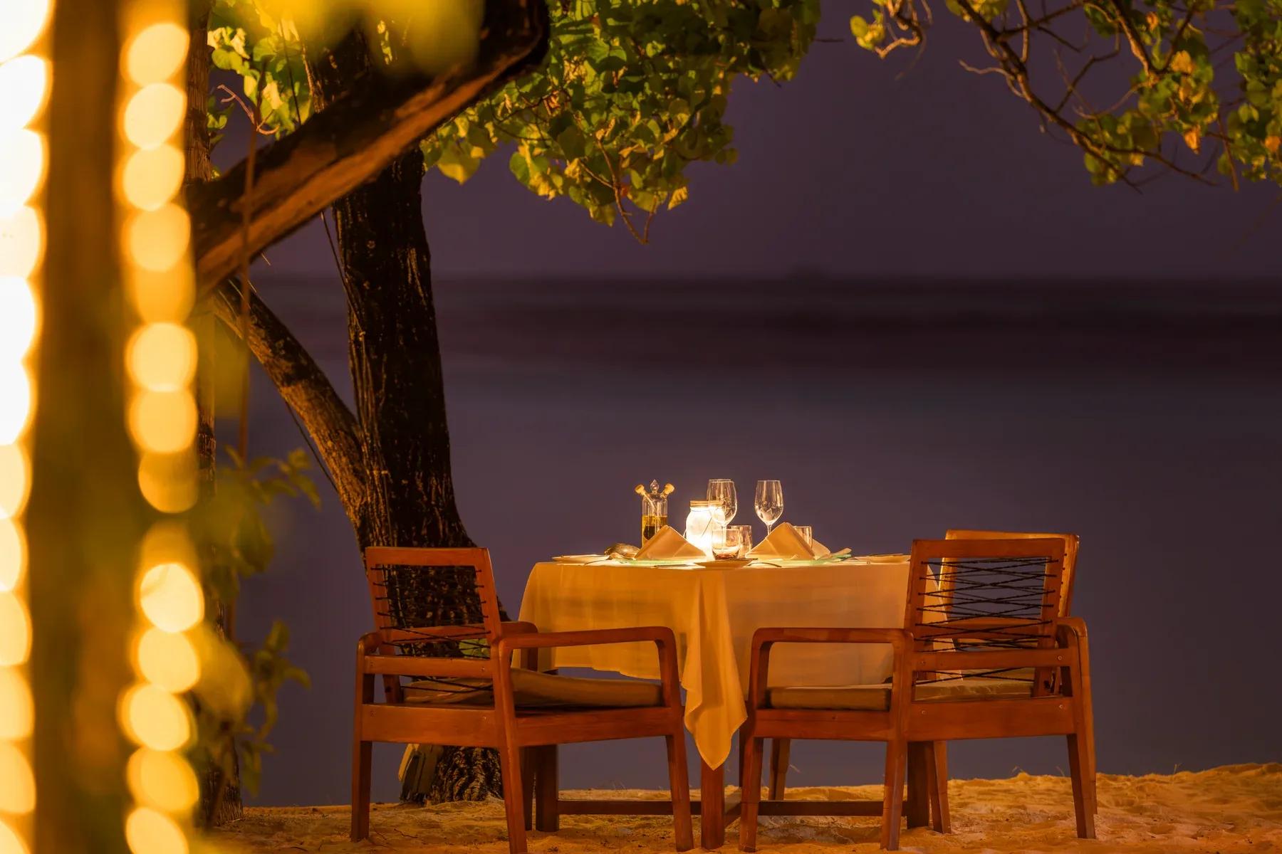 Tavolo apparecchiato con due sedie sulla spiaggia al Constance Moofushi.