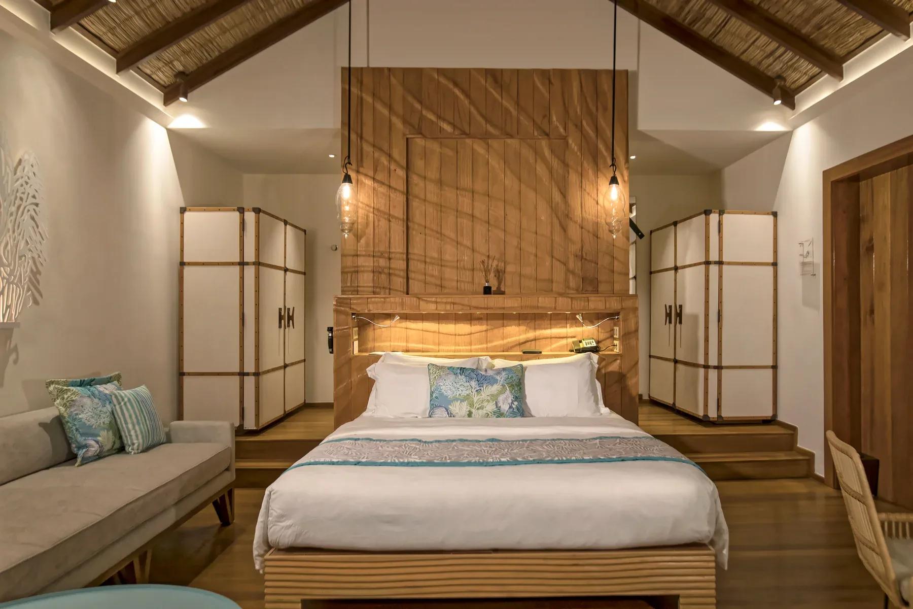 Interno della Sand Villas con letto matrimoniale e divano presso Constance Moofushi.