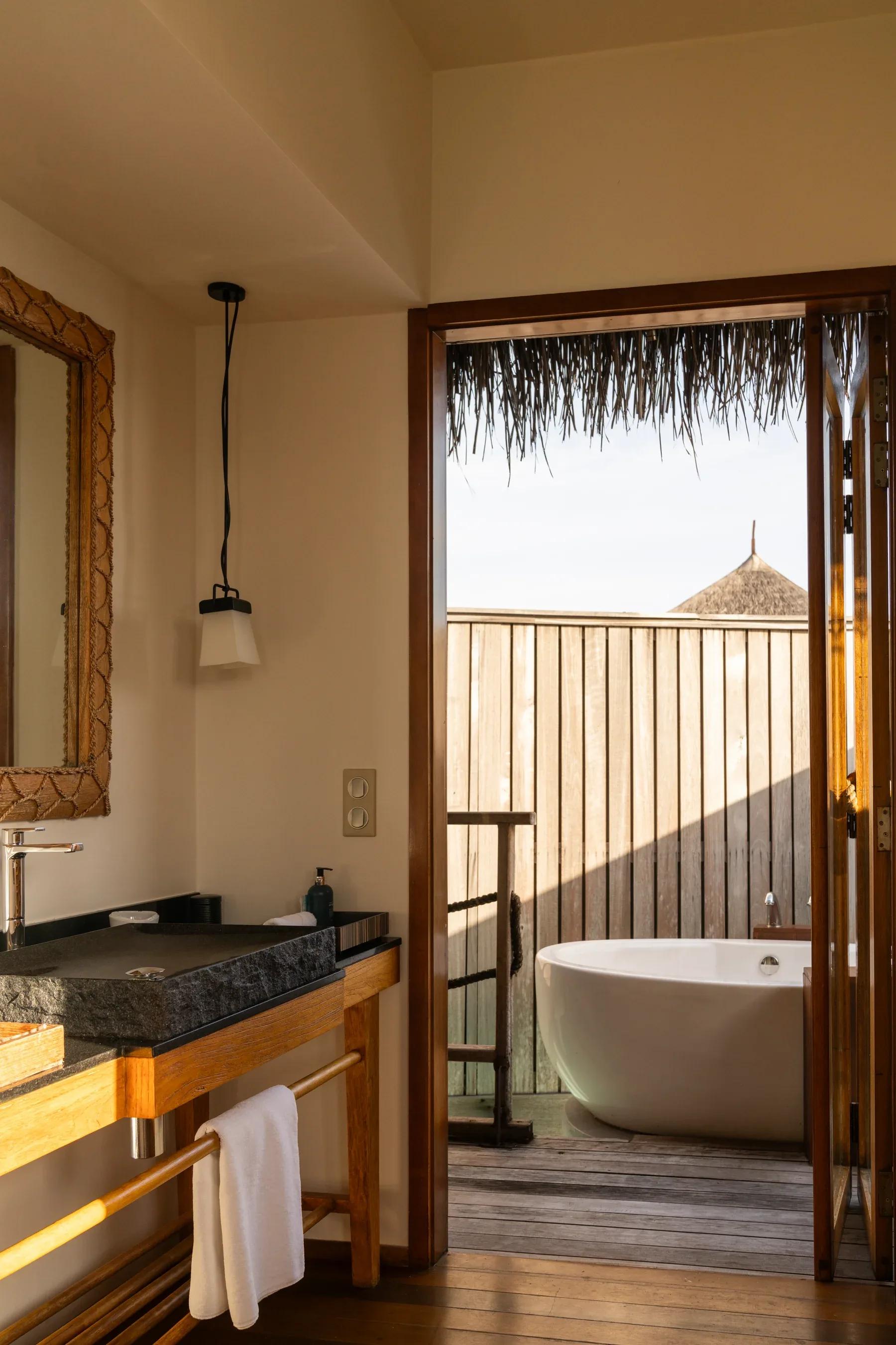 Bagno della Senior Water Villas con lavabo in pietra e vasca esterna al Constance Moofushi.