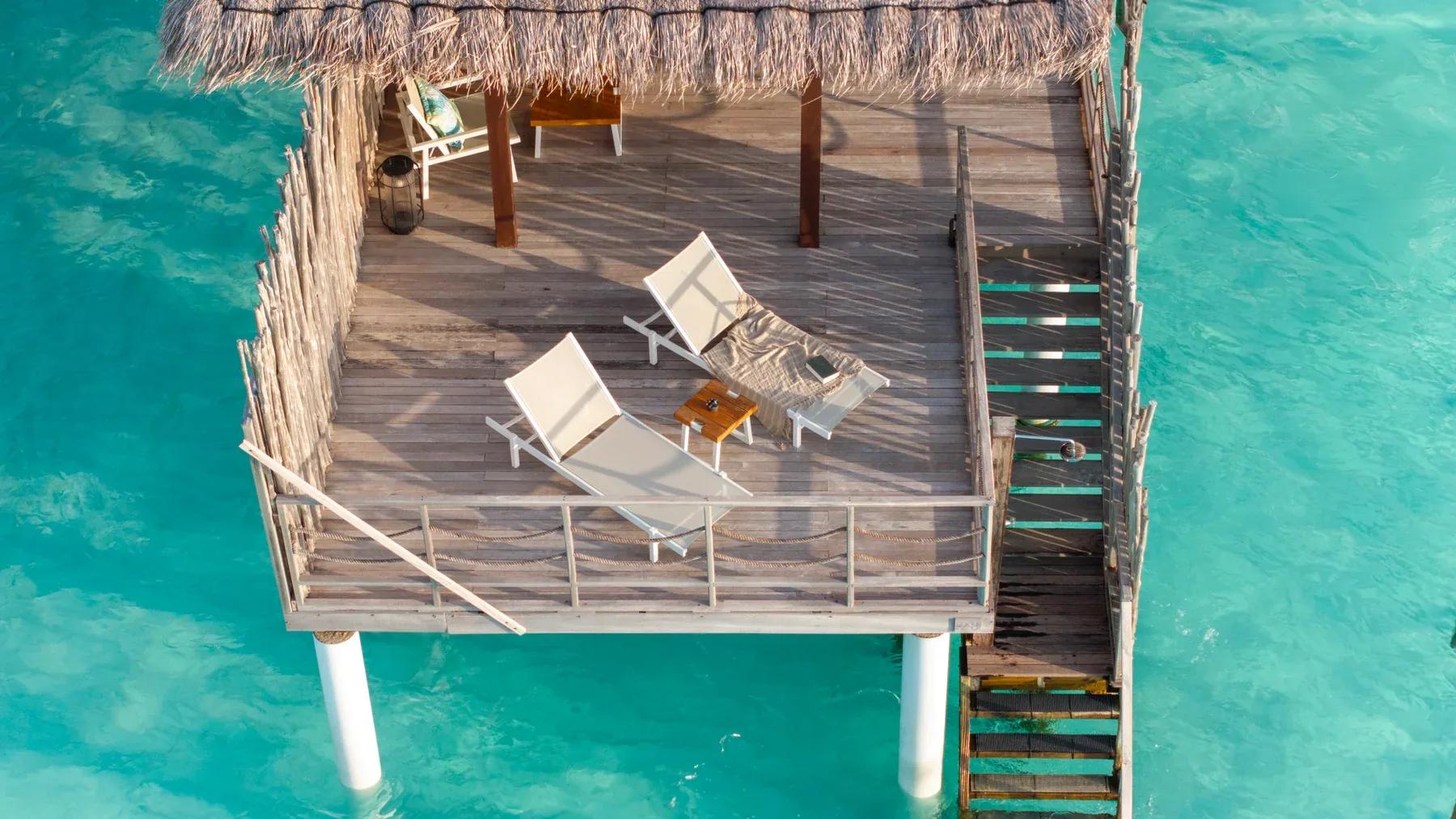 Terrazza della Water Villas con sedie a sdraio e accesso diretto al mare del Constance Moofushi