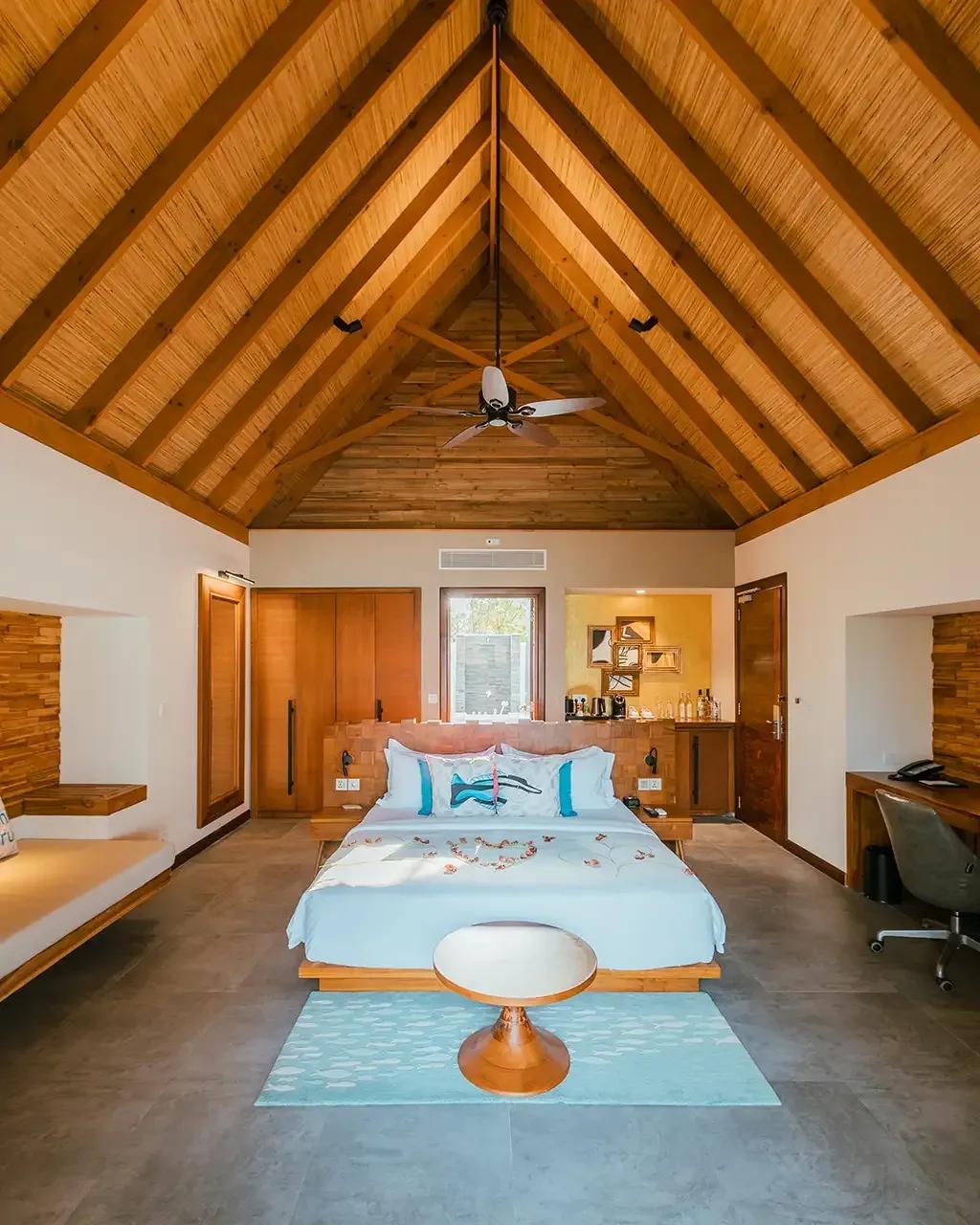 Camera da letto con soffitto in legno e ventilatore a soffitto nella Beach Villa Sunset al Fushifaru Maldives