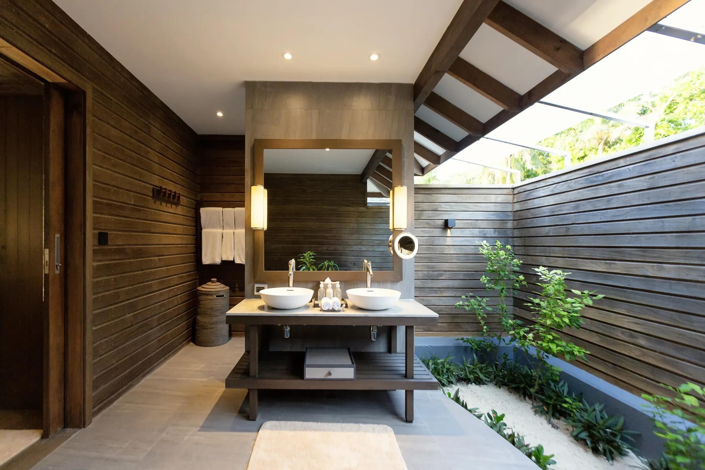 Bagno della Dheru Three Bedroom Villa con doppio lavabo e piantine al resort Jawakara Islands Maldives.