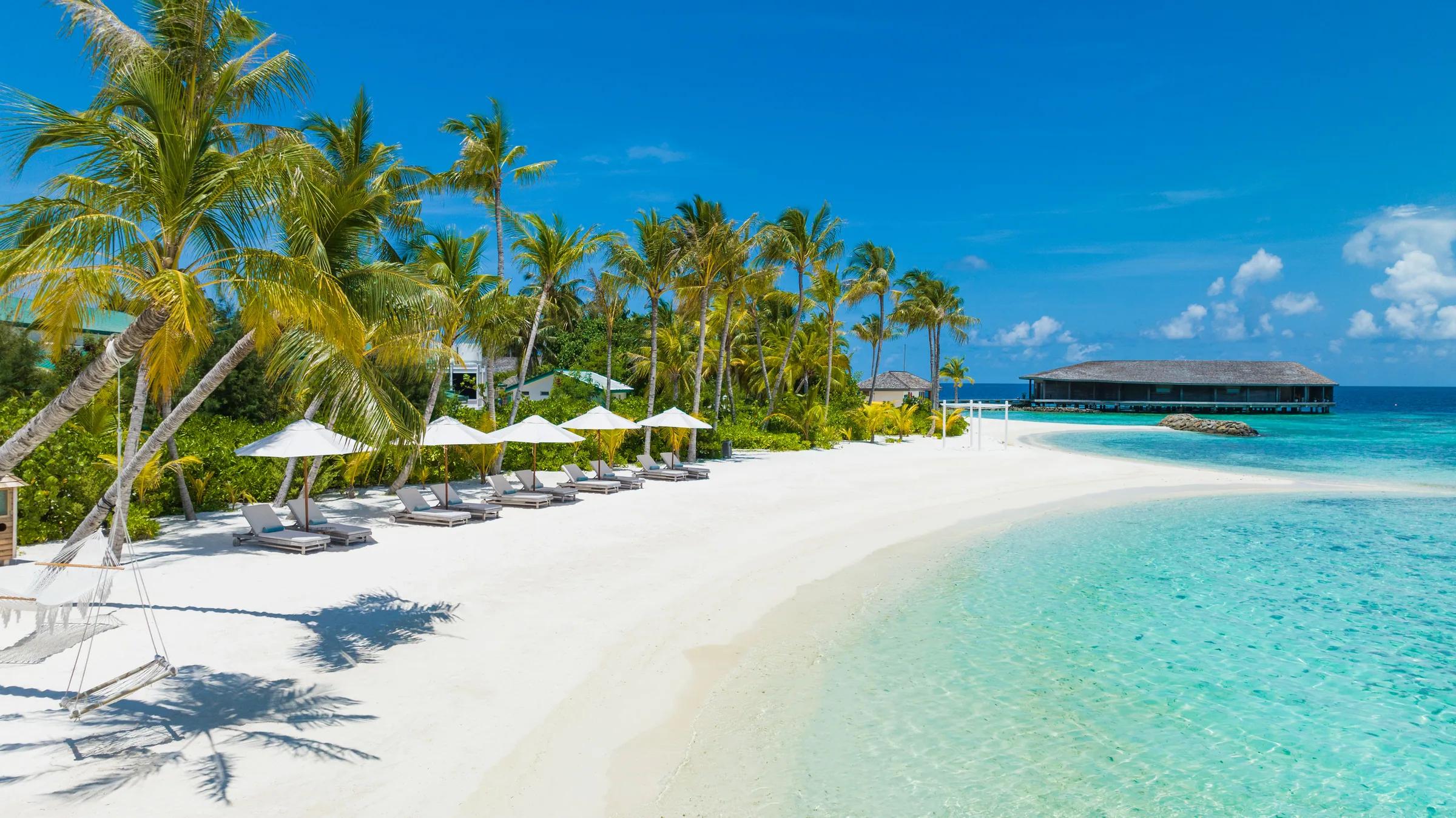Spiaggia con lettini e palme al Kagi Maldives Spa Island