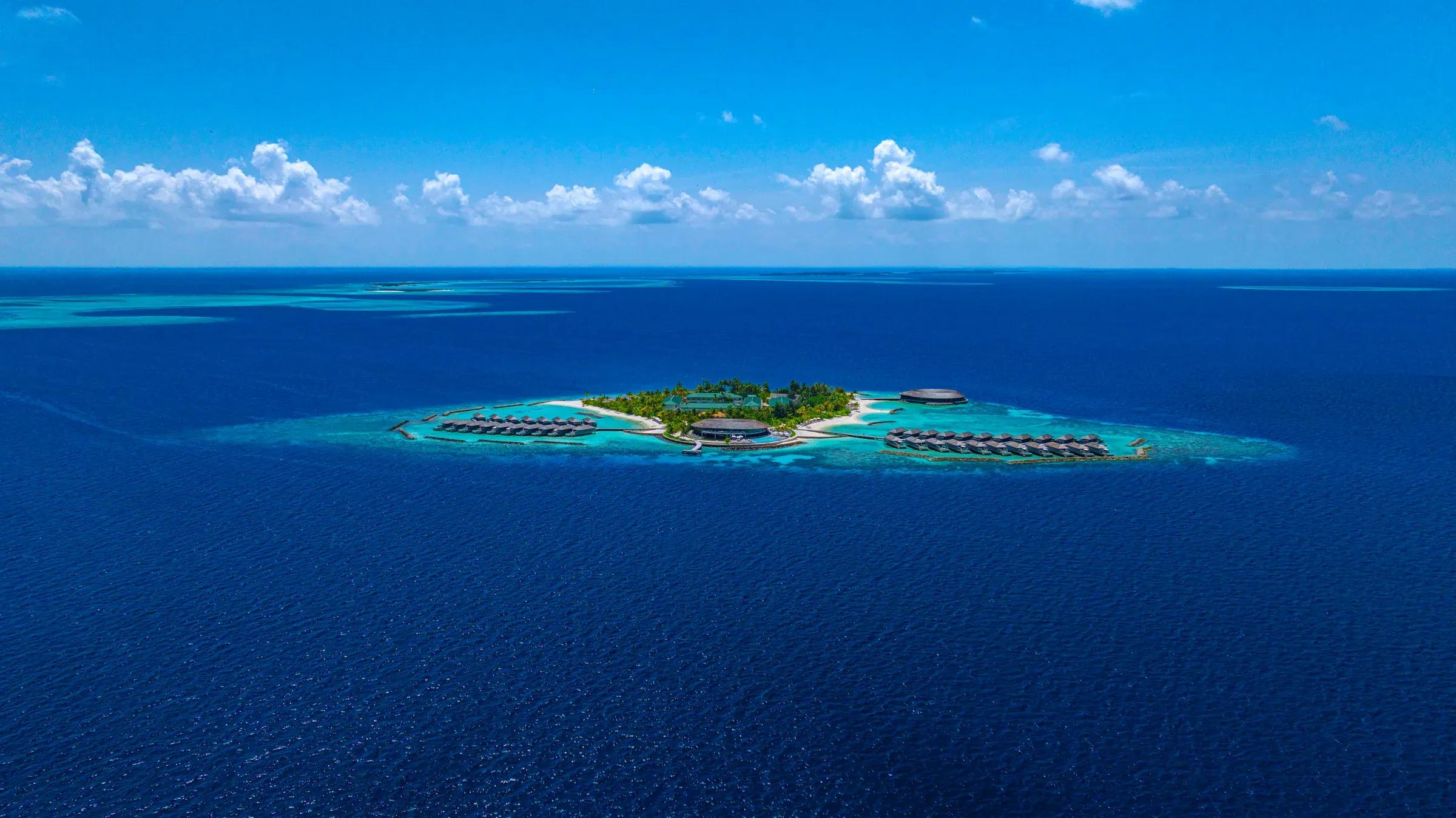 Vista aerea del Kagi Maldives Spa Island circondato dall'oceano blu.