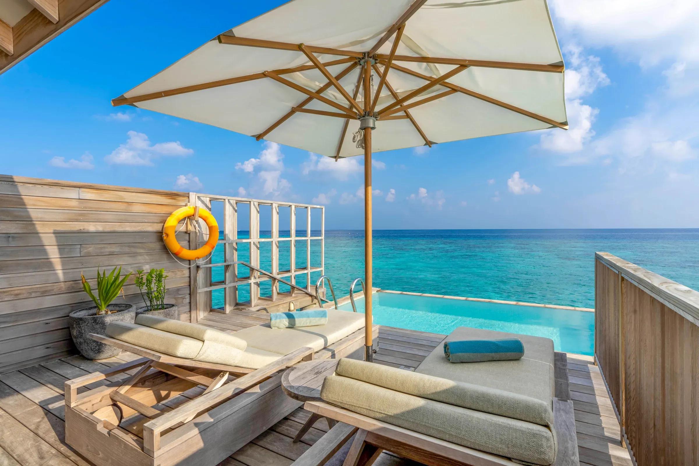 Terrazza della Ocean Pool Villa con lettini in legno e vista sull'oceano al Kagi Maldives Spa Island.