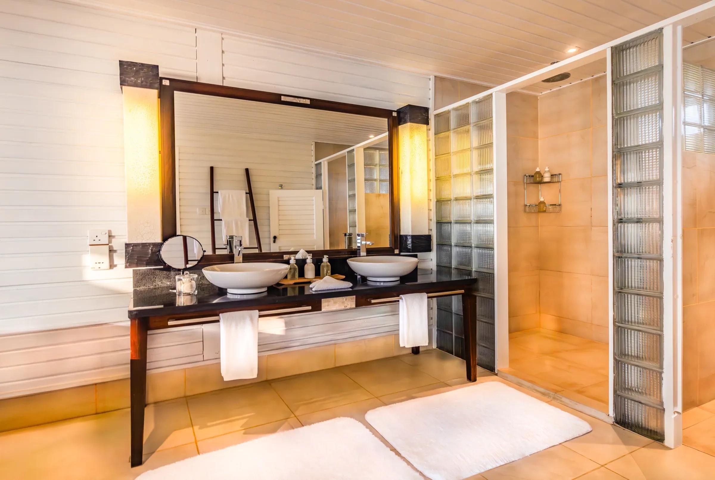 Bagno della Jacuzzi Water Villa con doppio lavabo, doccia e grandi specchi al Komandoo Island Resort & Spa.