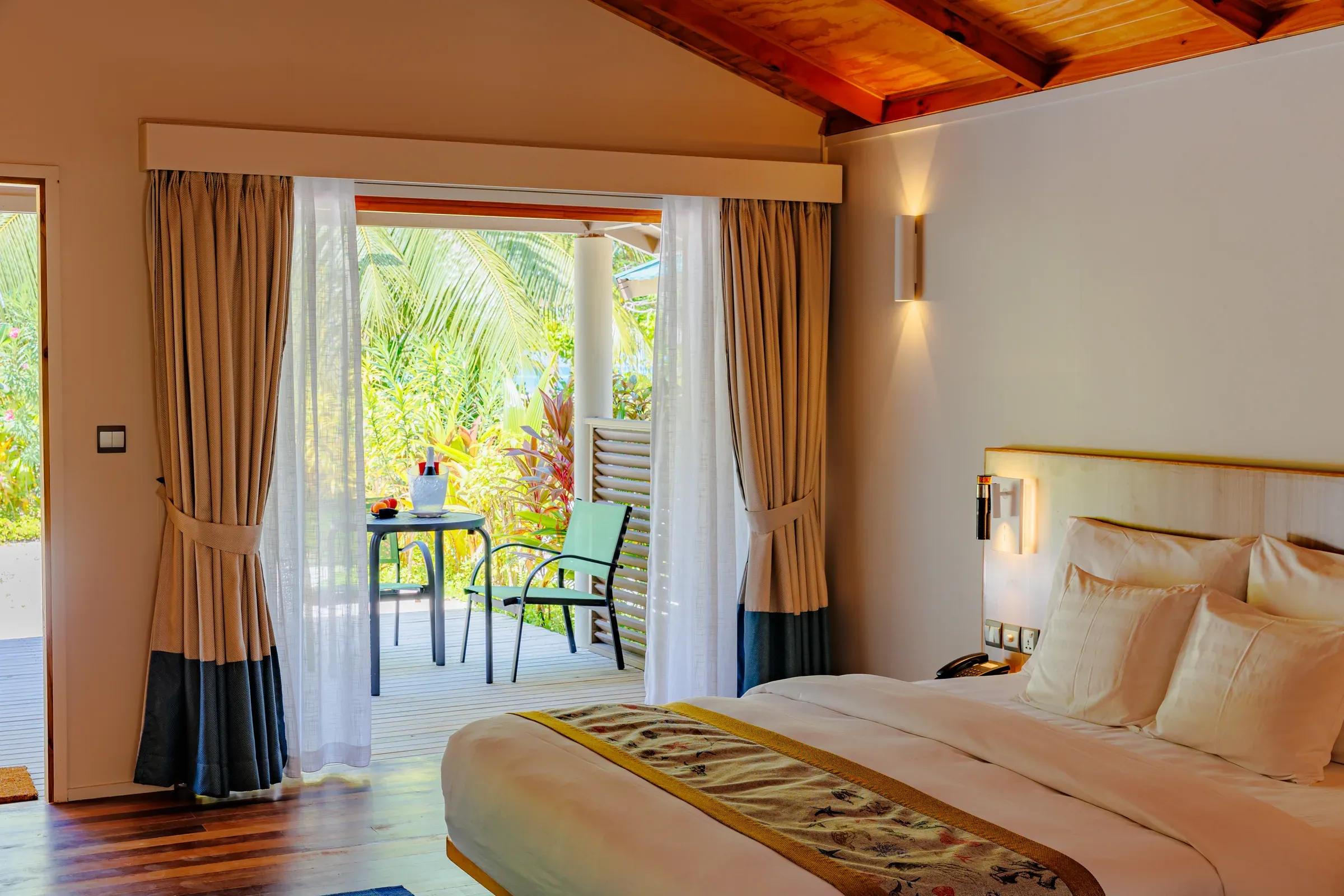 Camera da letto della Family Villa con letto matrimoniale e terrazza al Meeru Island Resort & Spa.