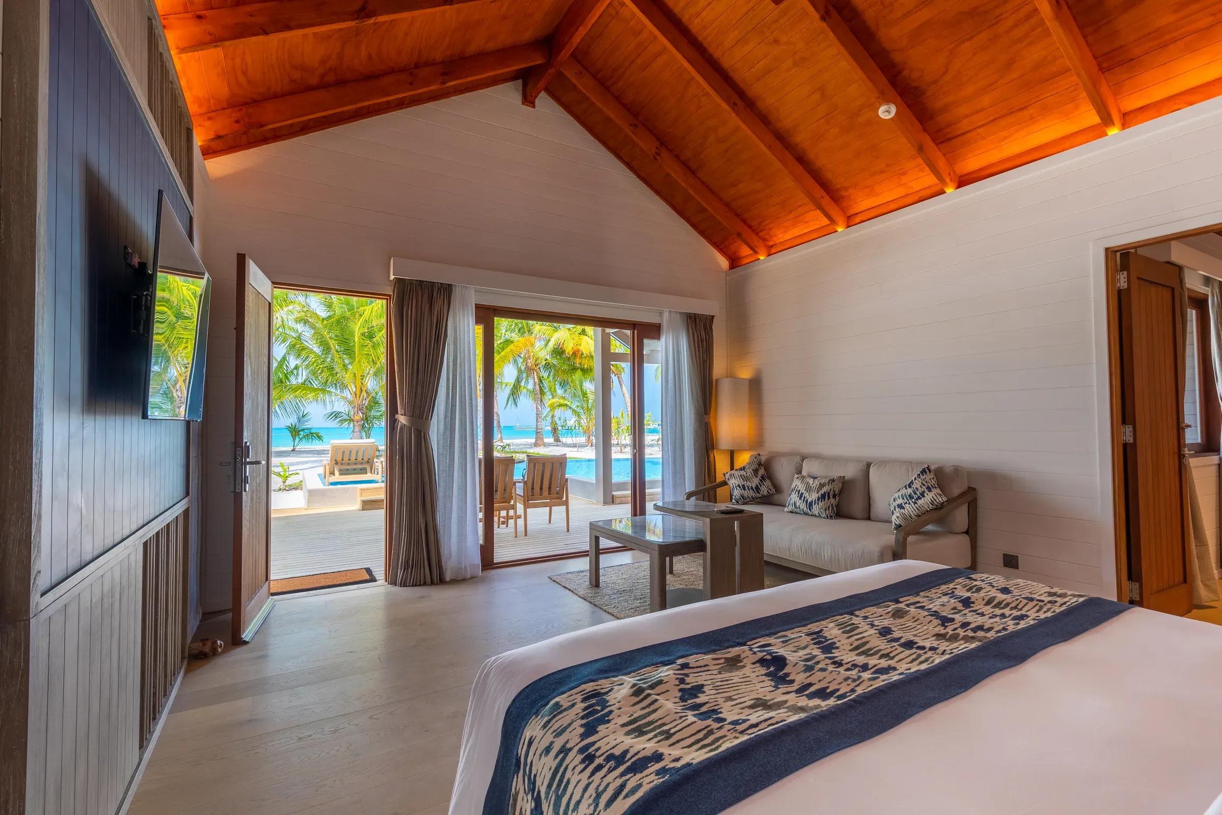Vista dall'interno della Two Bedroom Beach Pool Villa con salotto e accesso alla terrazza vista mare del Meeru Island Resort & Spa.