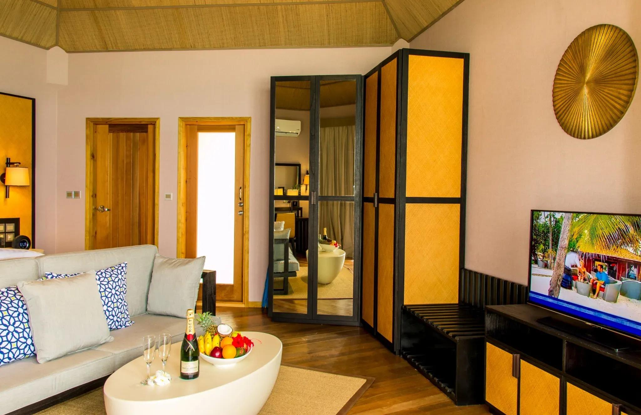 Soggiorno della Water Front Villa con divano e TV al Meeru Island Resort & Spa.