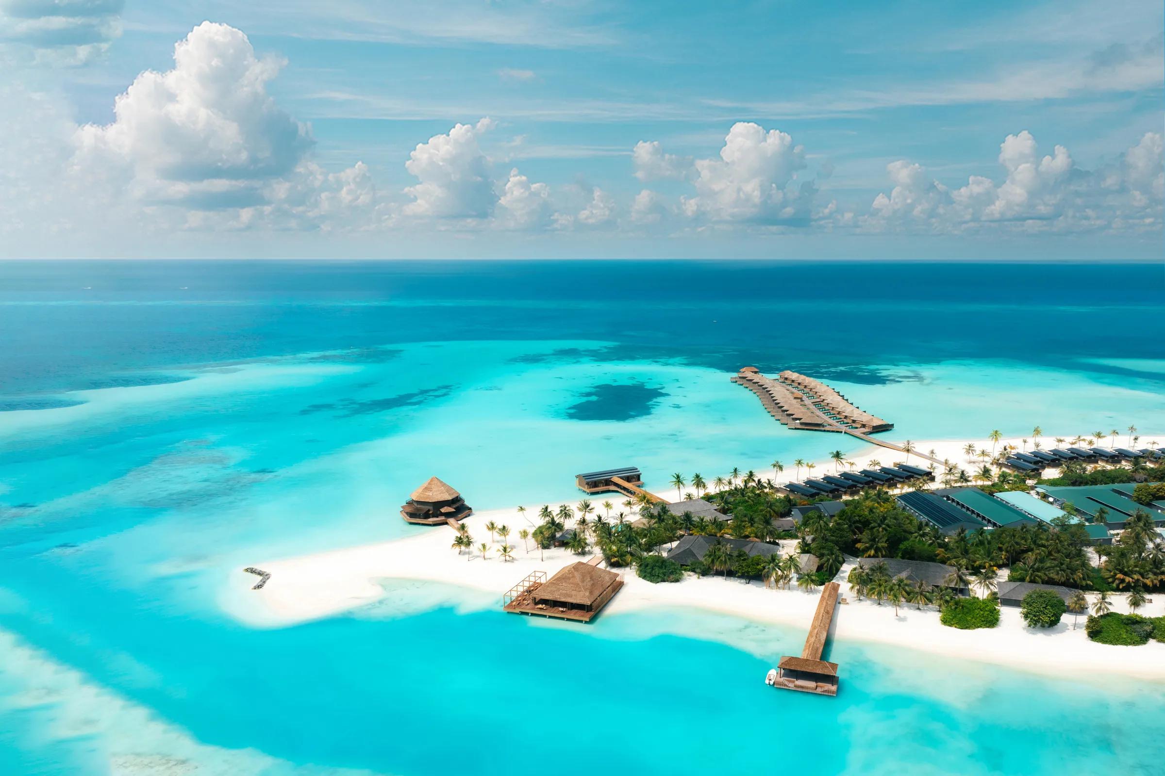 Vista aerea del resort Nala Maldives By Jawakara con palme e acqua cristallina.