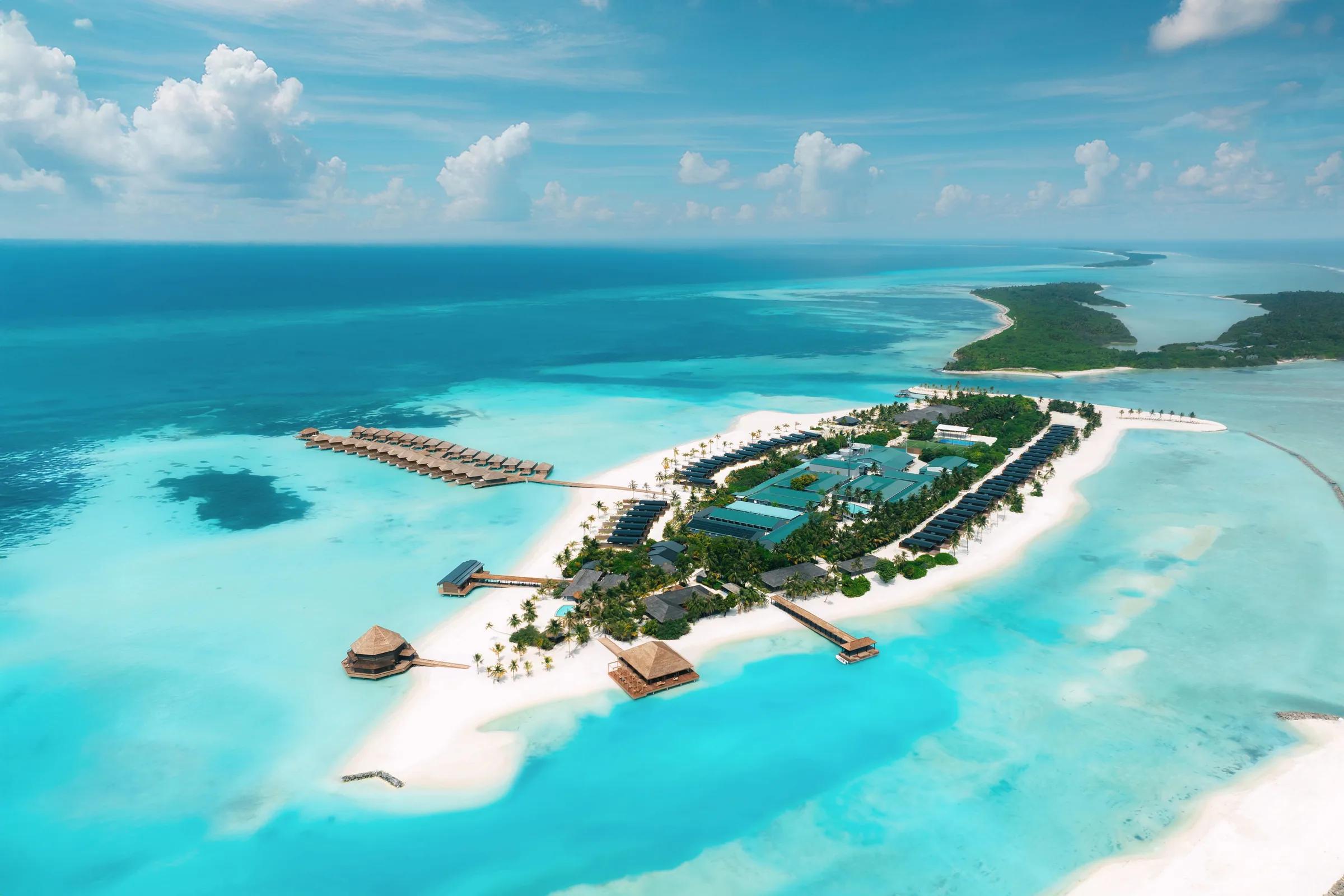 Vista aerea dell'isola del Nala Maldives By Jawakara con ville sull'acqua e spiagge bianche circondate da laguna turchese.