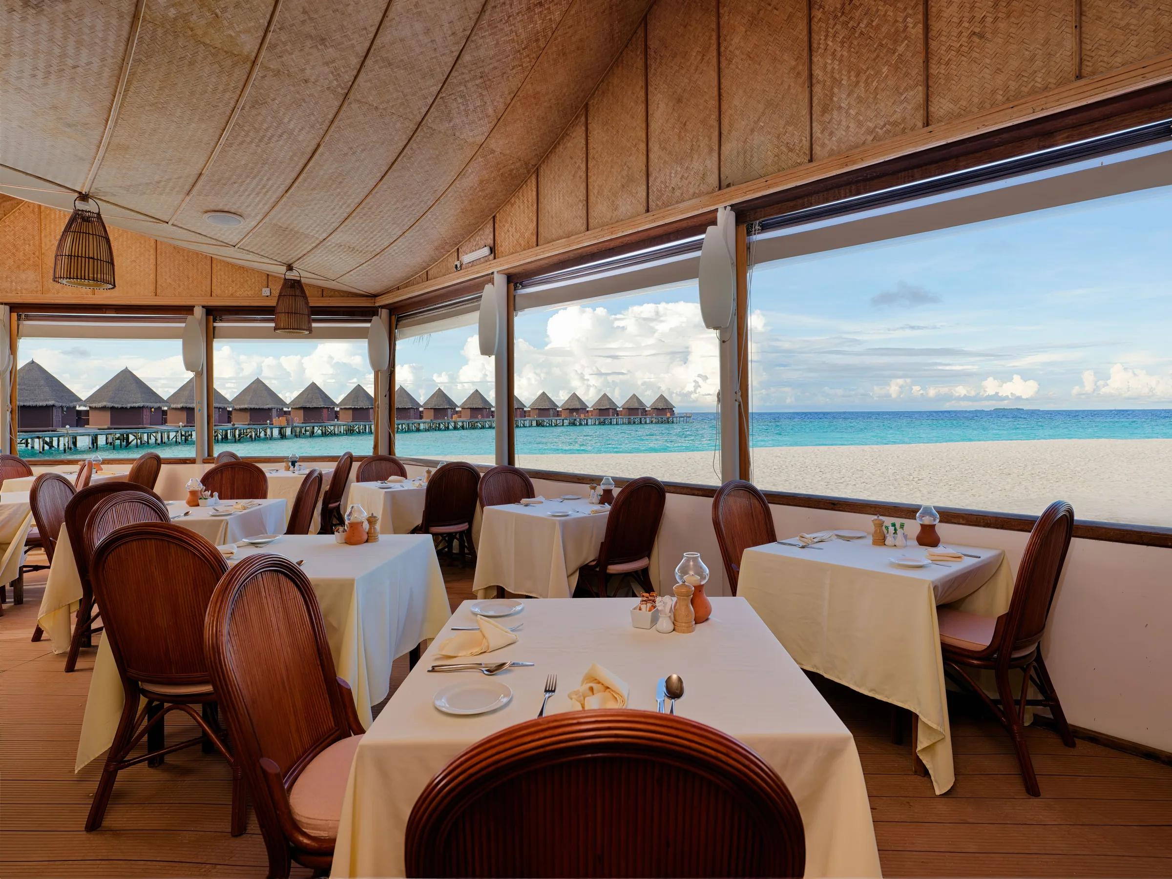 Vista del Main restaurant con tavoli e vista sull'oceano al Thulhagiri Island Resort & Spa