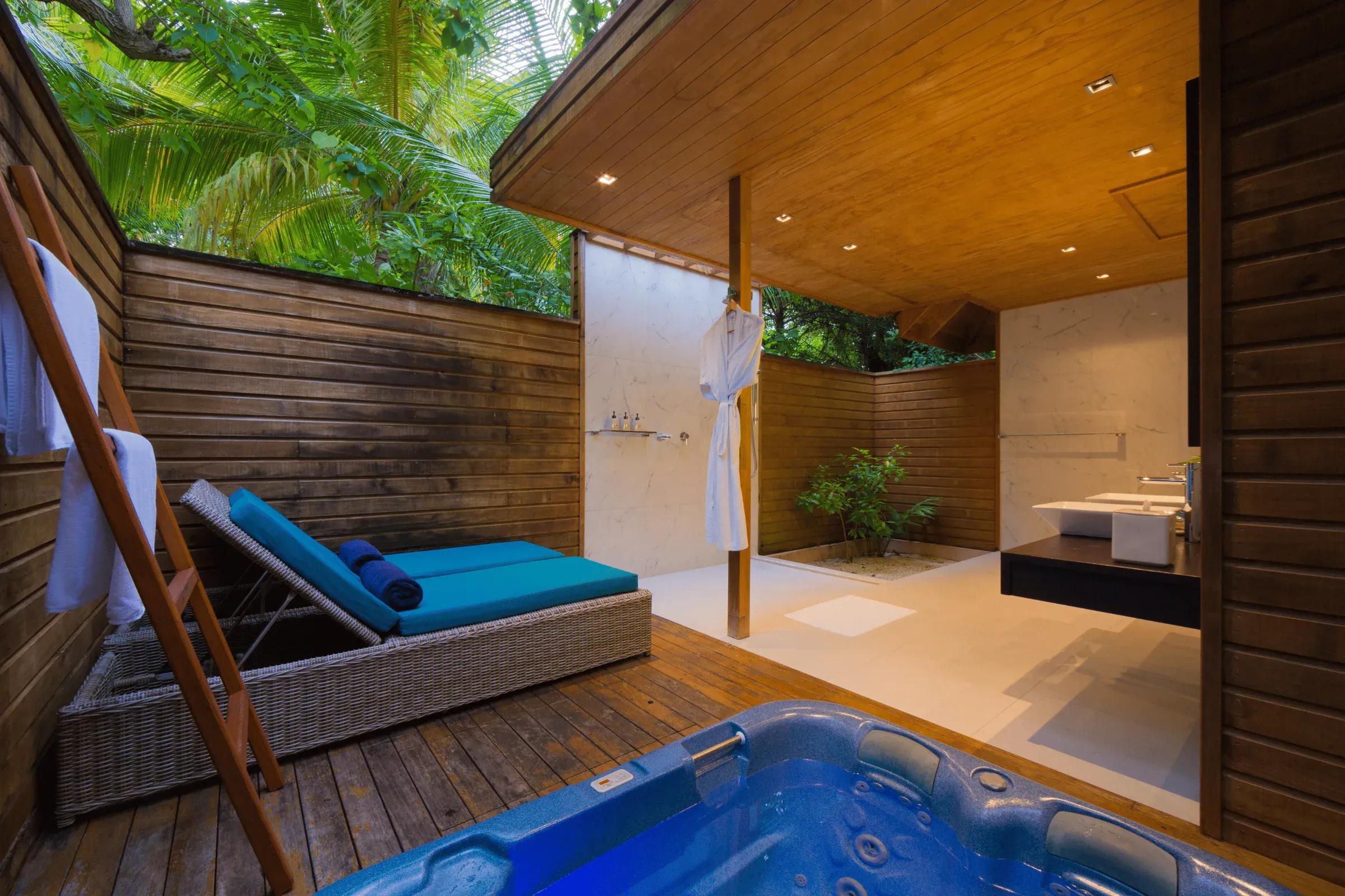 Jacuzzi Beach Villa con area esterna attrezzata di lettino e vasca idromassaggio al Veligandu Island Resort & Spa.