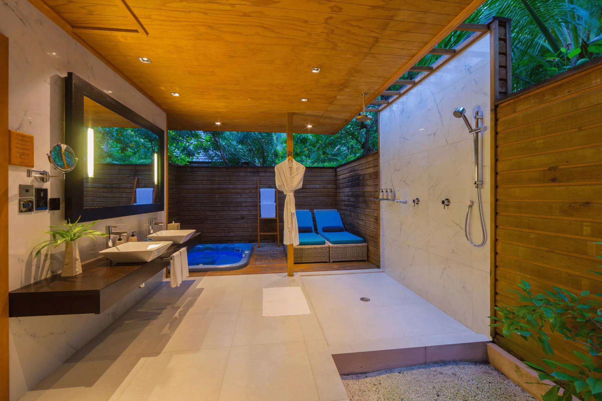 Jacuzzi Beach Villa con doccia esterna, lettini e jacuzzi al Veligandu Island Resort & Spa.