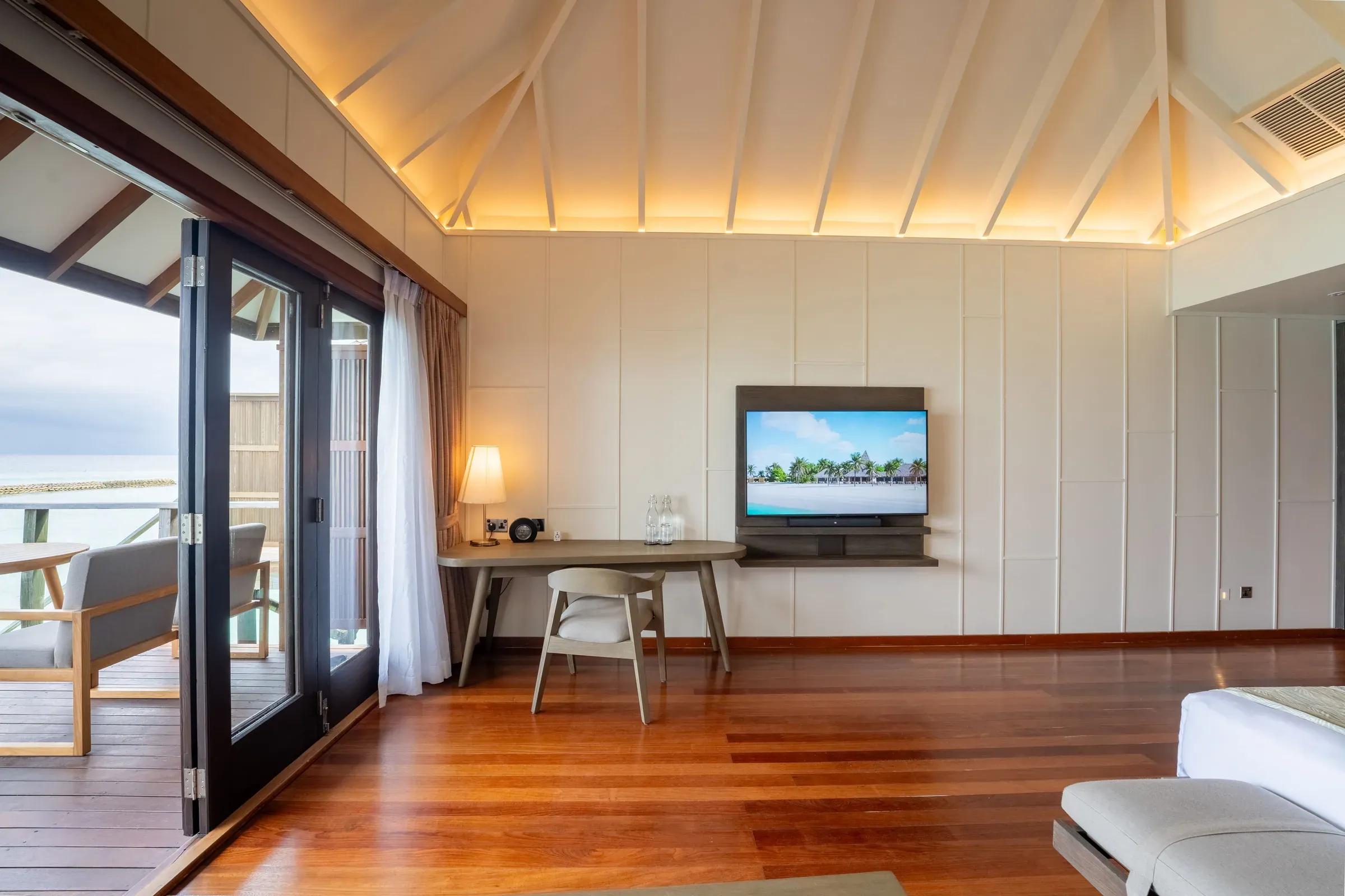 Interno della Ocean Jacuzzi Villa con TV e accesso alla terrazza del Veligandu Island Resort & Spa.
