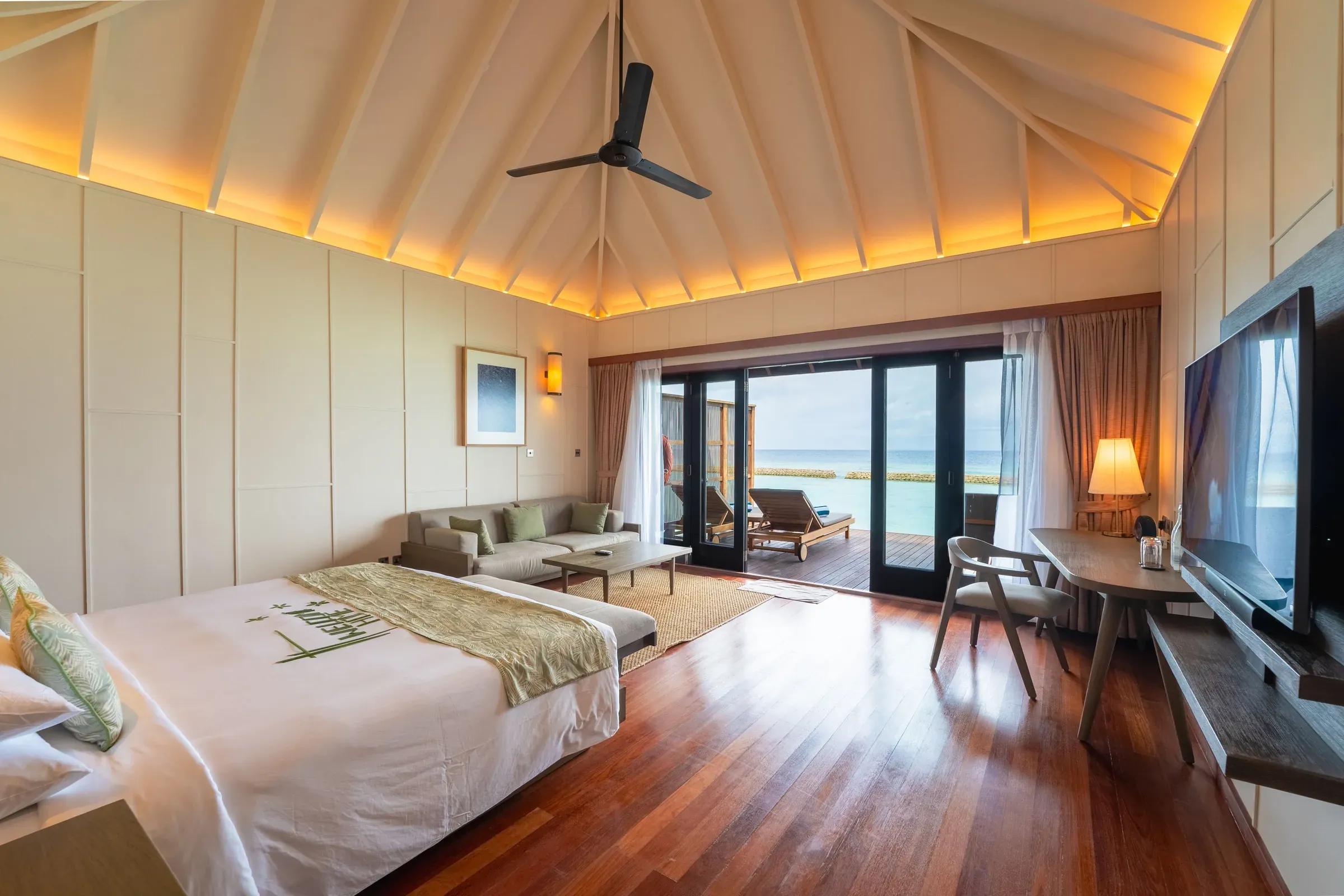Camera Ocean Jacuzzi Villa con letto matrimoniale, divano e vista mare al Veligandu Island Resort & Spa.