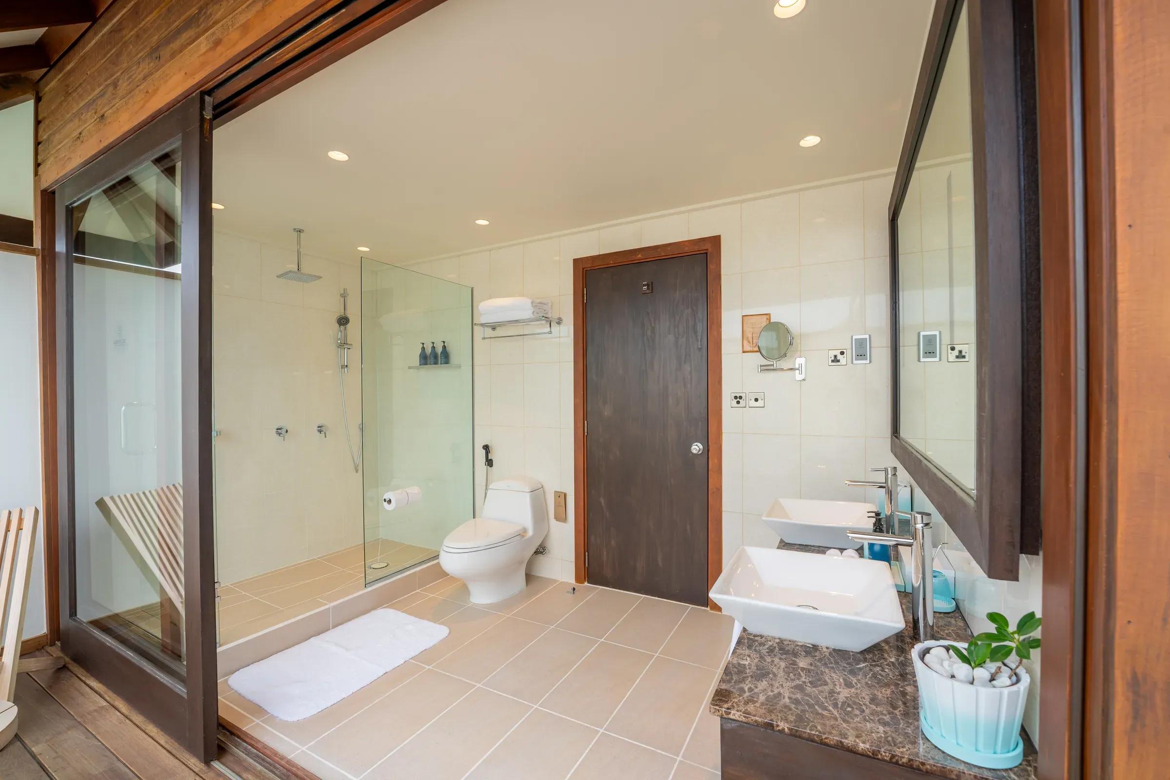 Bagno della Sunset Ocean Villa con doccia a vetri e doppi lavabi al Veligandu Island Resort & Spa.